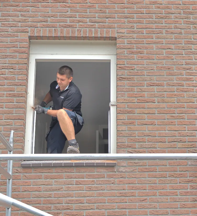 Man sloopt oude kozijn eruit